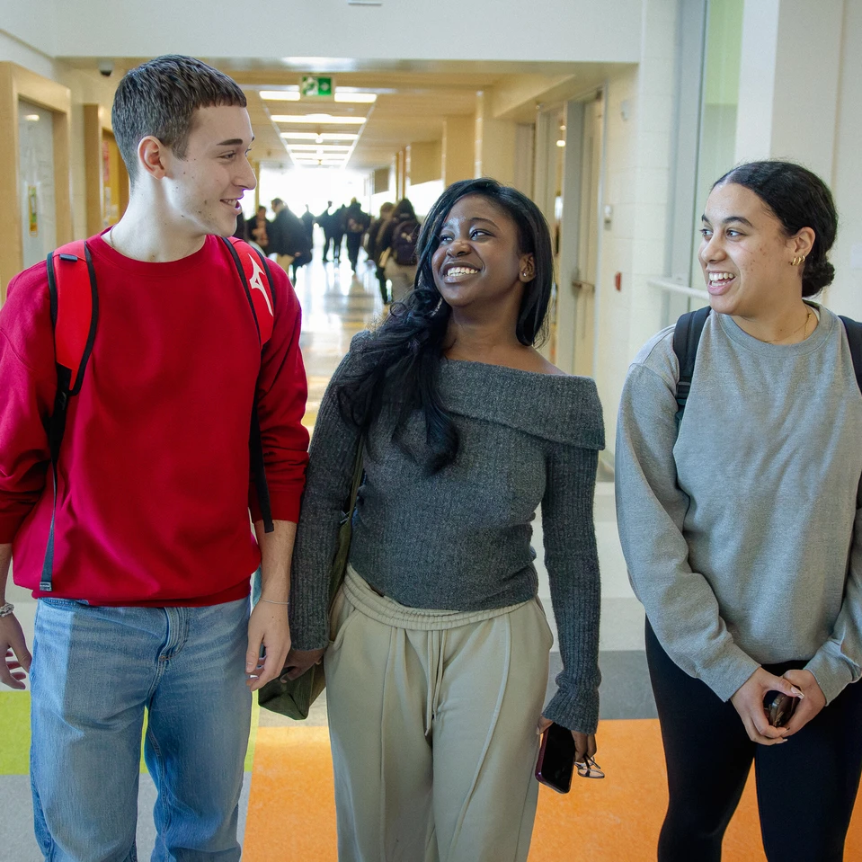 trois élèves marchant dans le corridor de l'école